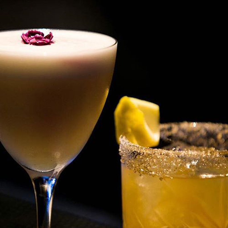 A smooth white cocktail and a yellow cocktail with sugar.