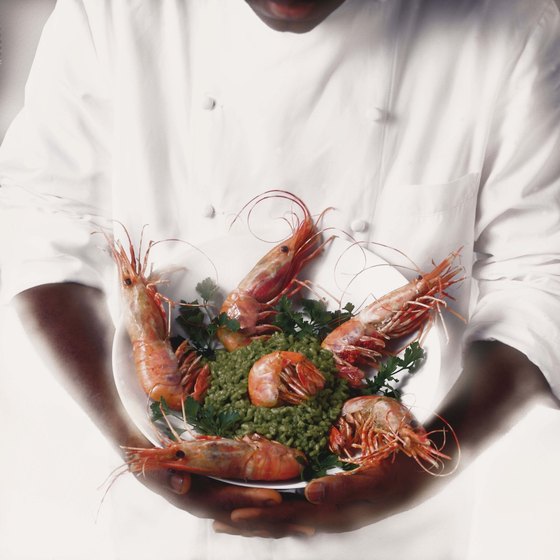 a chef holding a bowl with crawfish and salad