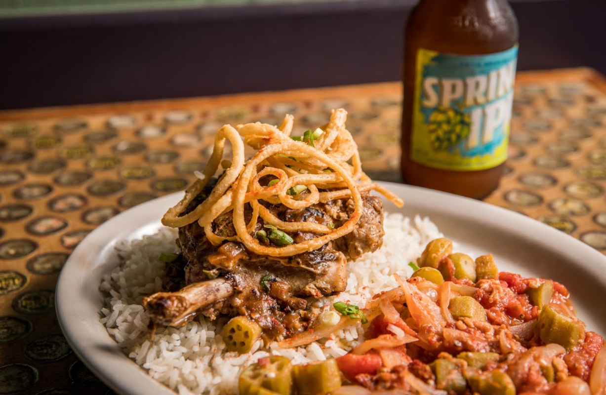 Grilled meat with onion rings, rice and salad