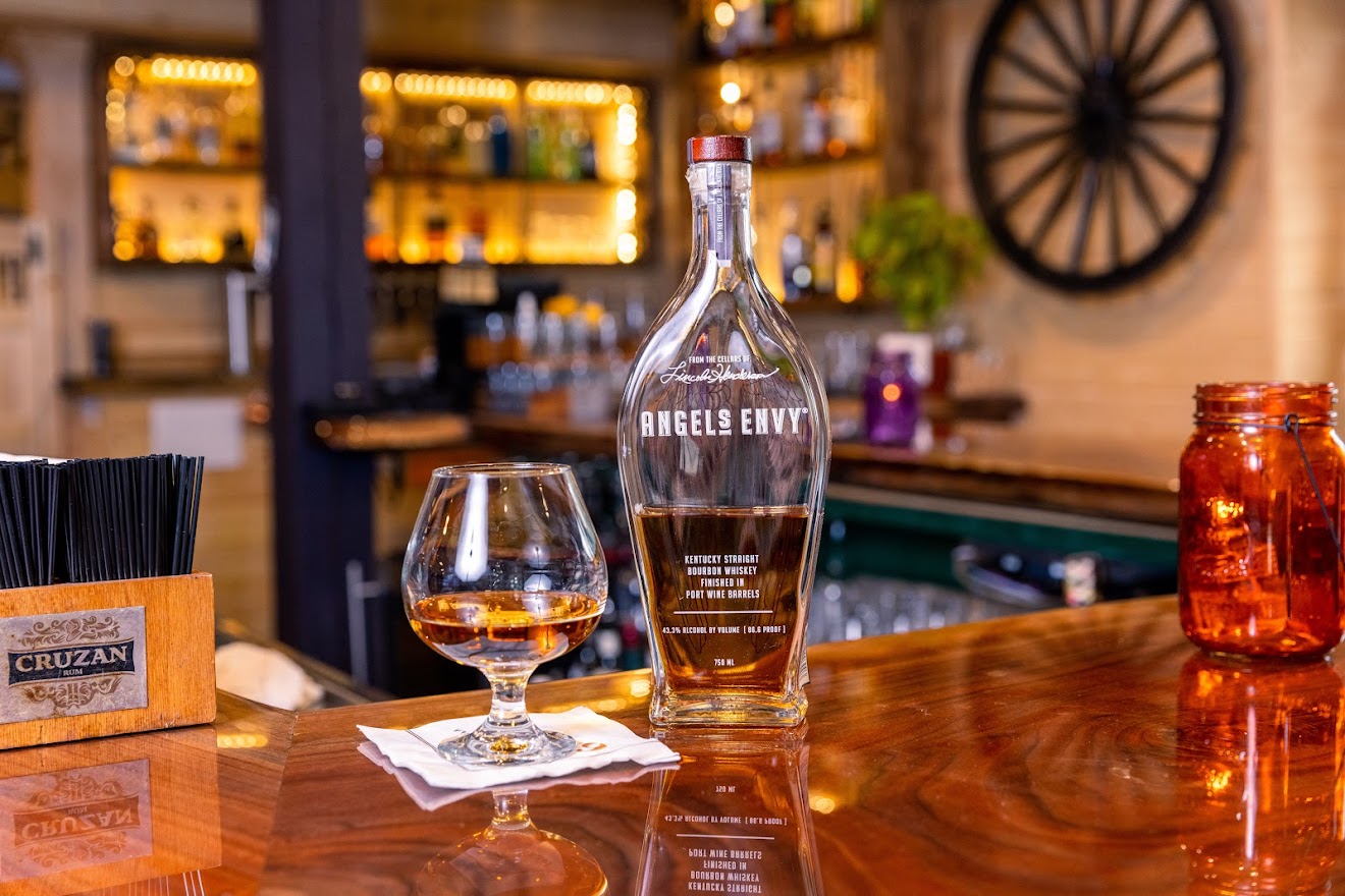 A bottle and a glass of Kentucky straight bourbon whiskey served on a bar