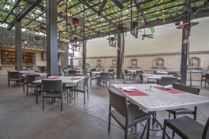Tables set on the outdoor vine arbor patio