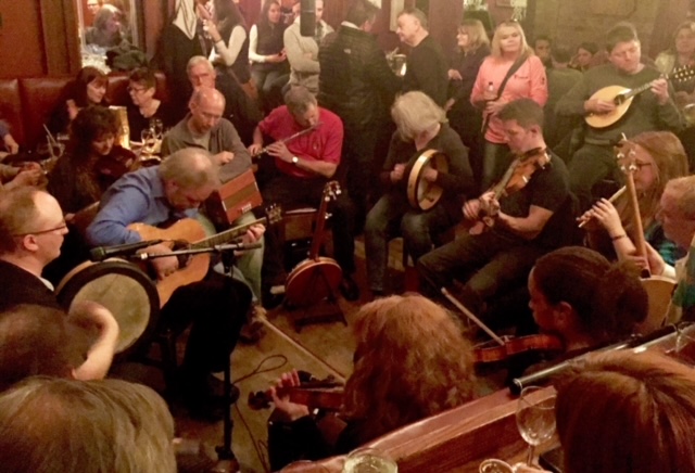 A group of musicians in a bar with audience