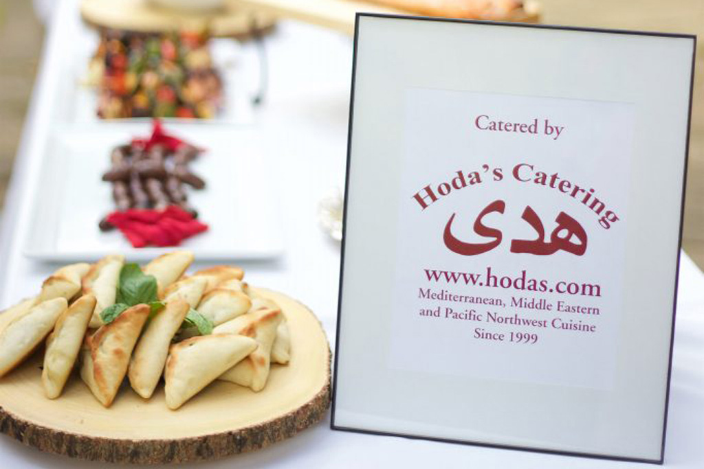 Hoda's Catering and a table with various dishes in the back