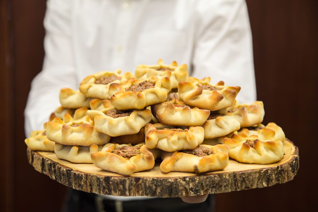 Chef holding a board with filled pastries