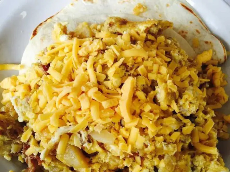 Tortilla topped with shredded cheese