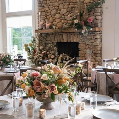A decorated wedding reception table with elegant flowers and flickering candles