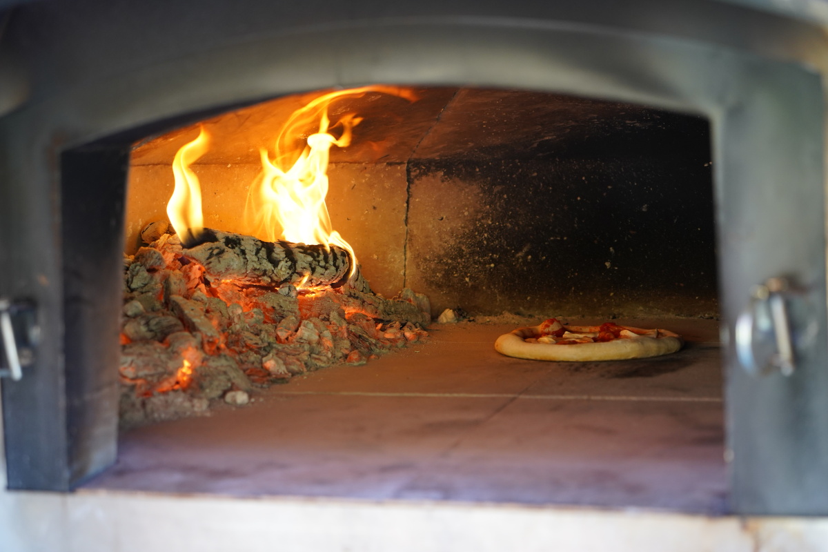 Pizza getting baked in wood fired oven