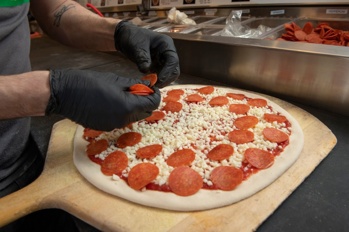 Staff member making pizza