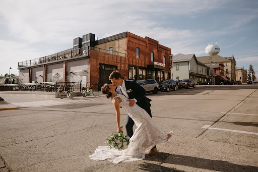 Bride and groom posing outside event venue building