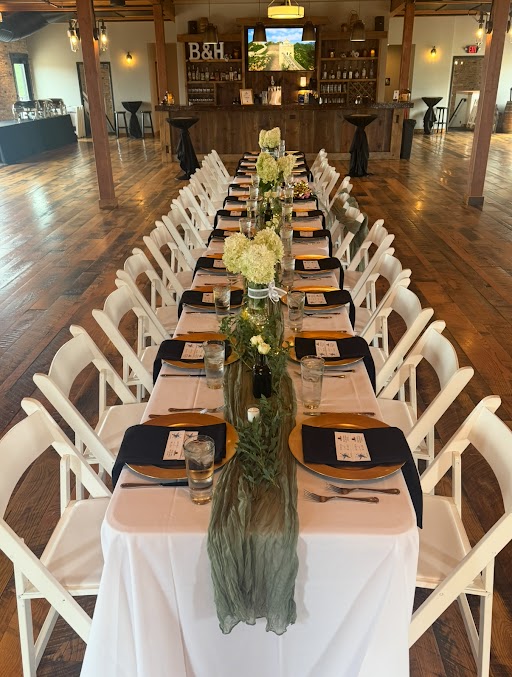 Long wedding reception table inside rustic event hall