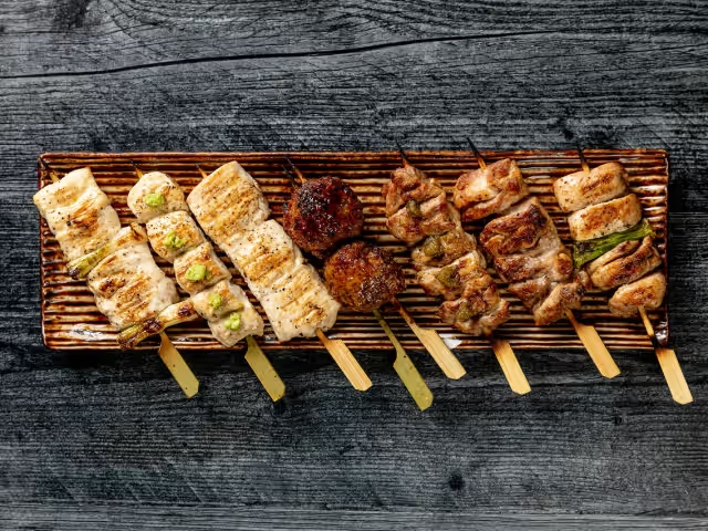 A wooden tray displaying an assortment of meats, showcasing a variety of cuts and types.