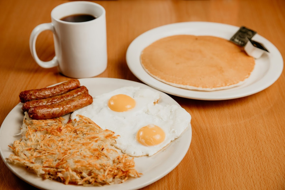 Fried eggs, sausages, pancakes and coffee on the side: