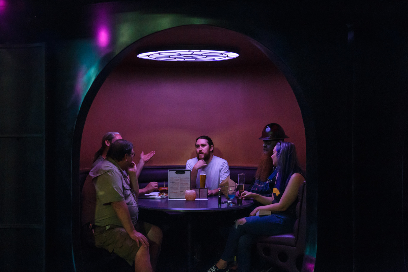 Interior, bar area, guests chatting and enjoying drinks in a private booth