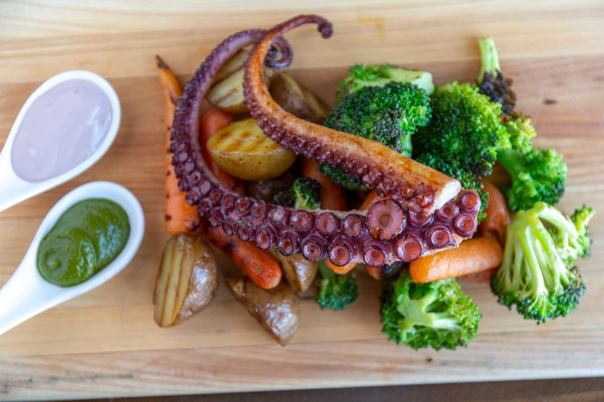 Grilled octopus served atop grilled vegetables