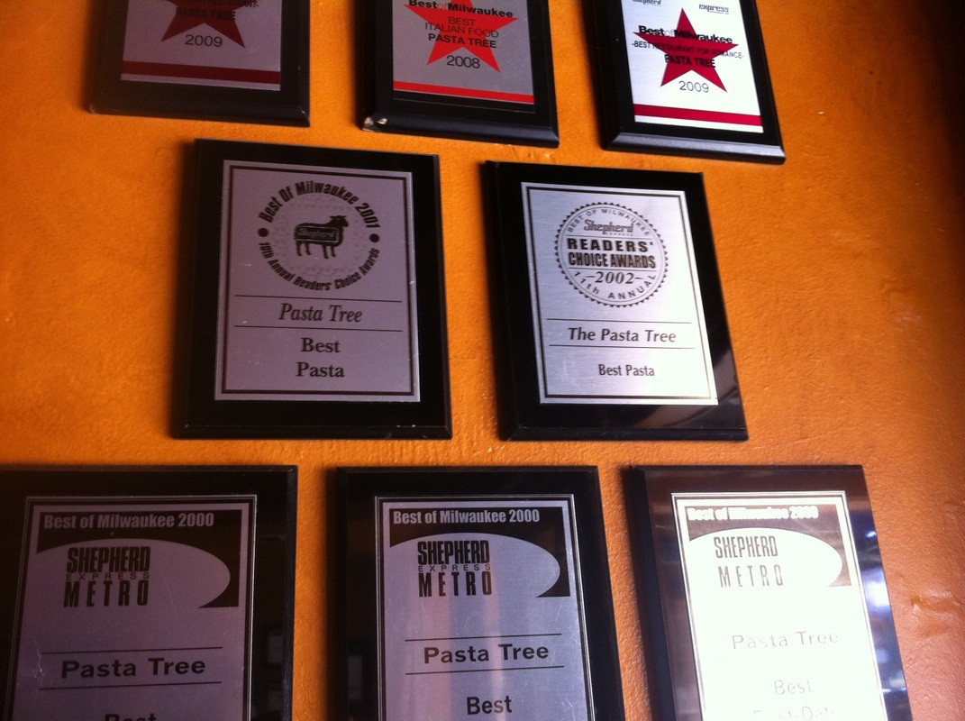 Photos of awards on orange wall
