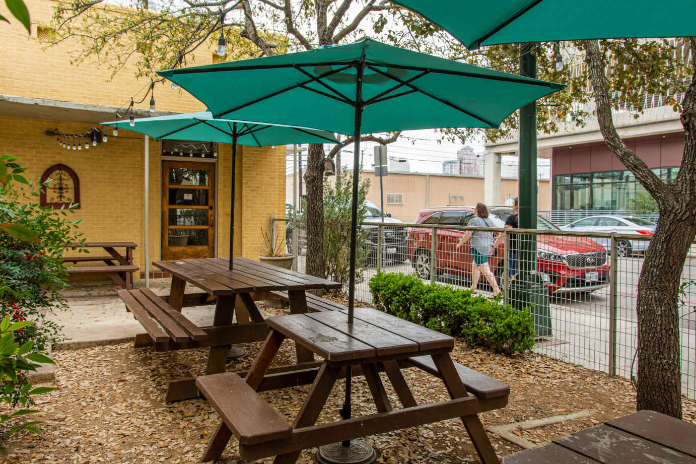 Exterior, patio, wooden tables and bench seating, parasols


    
