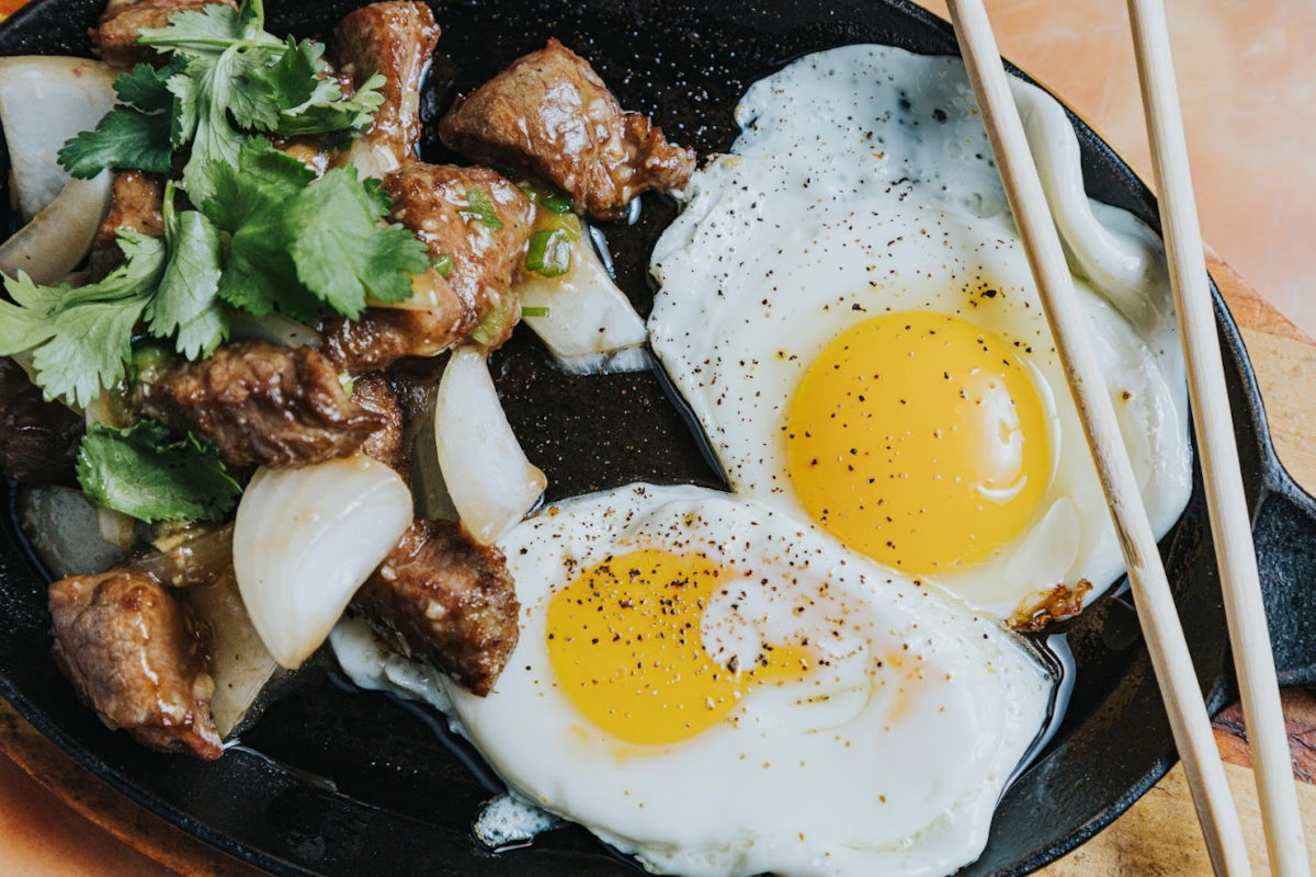 Grilled meat, salad and fried eggs