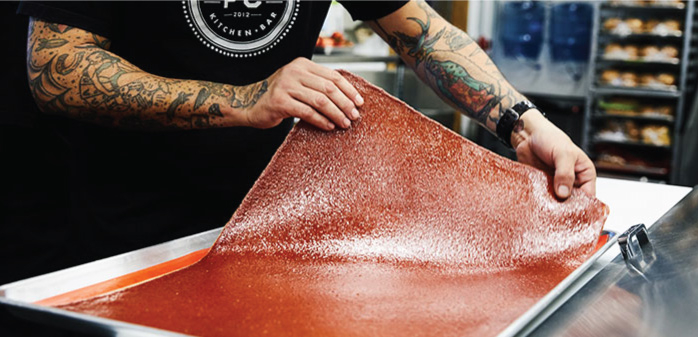 Staff member preparing a ketchup leather™