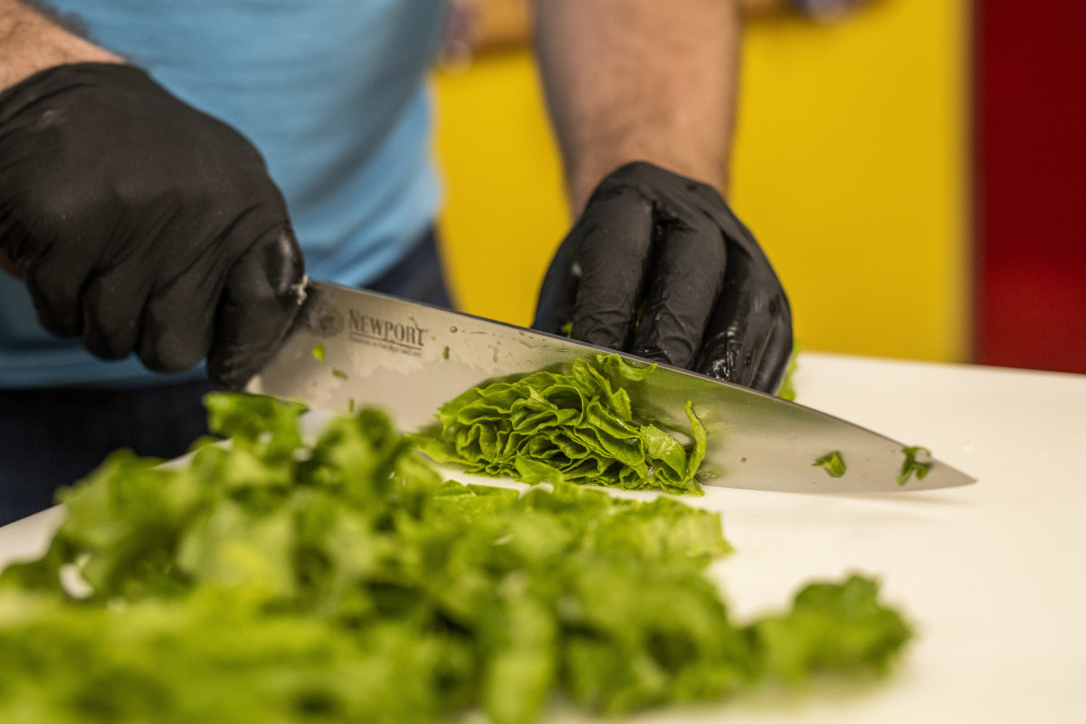 Employee cutting up salad