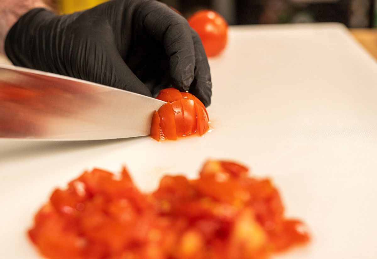 Staff member dicing tomatoes