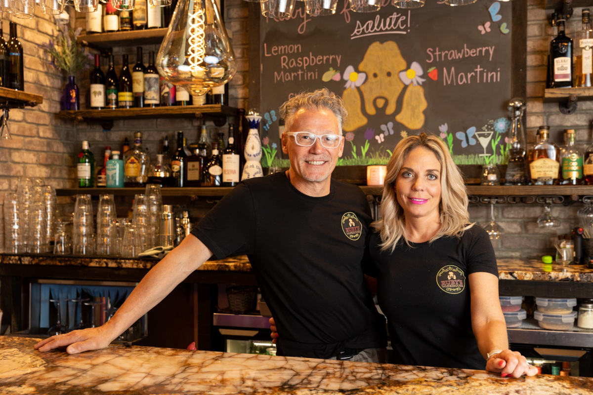 Owners posing behind the bar