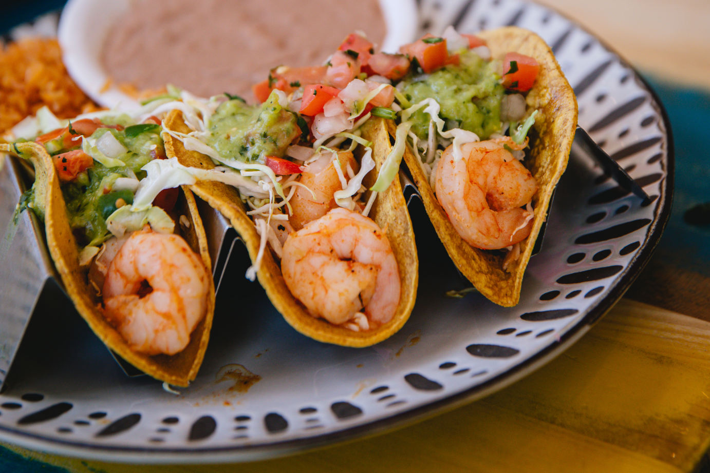 Three tacos with shrimps and salad