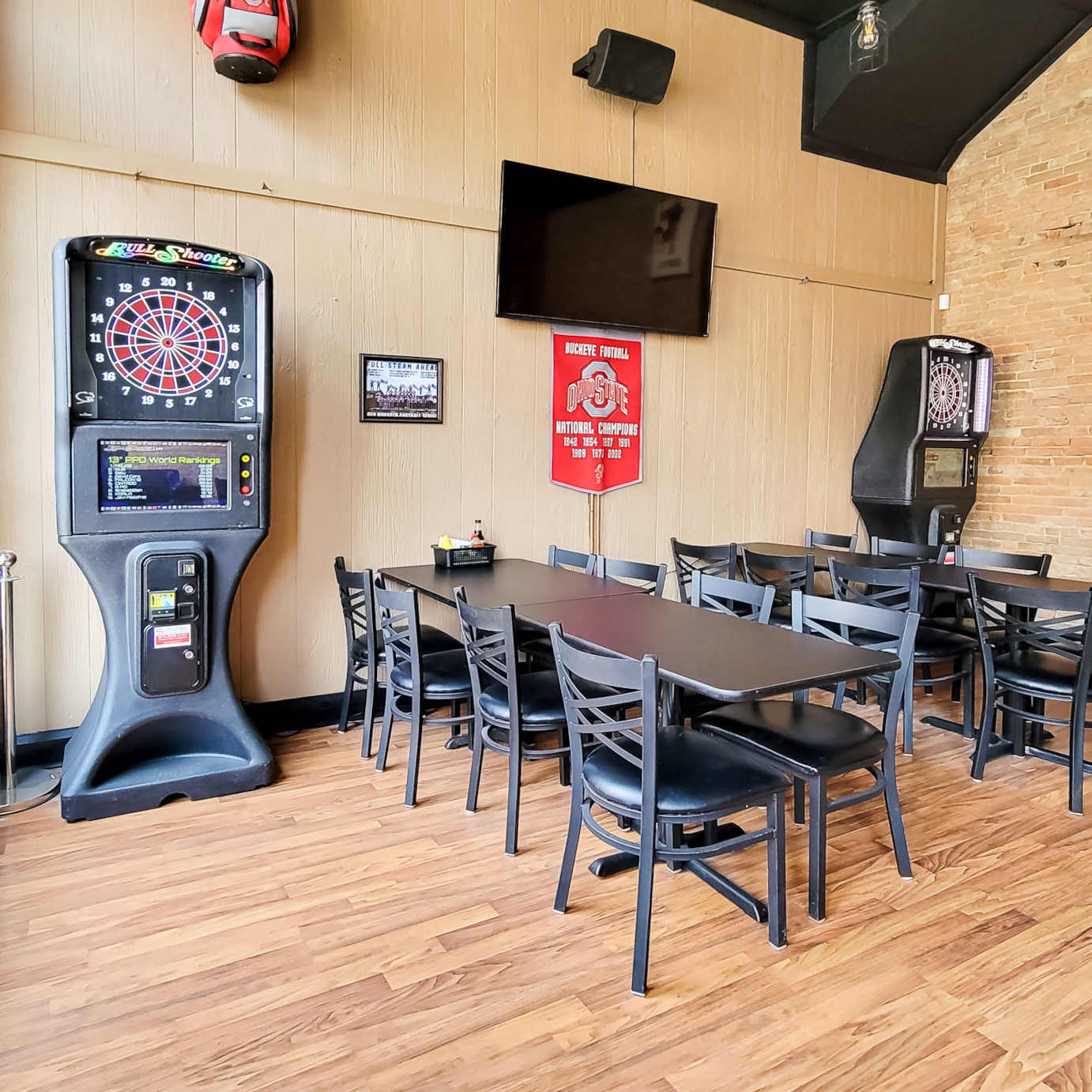 Interior, dining tables and chairs, two dartboard machines, wall TV