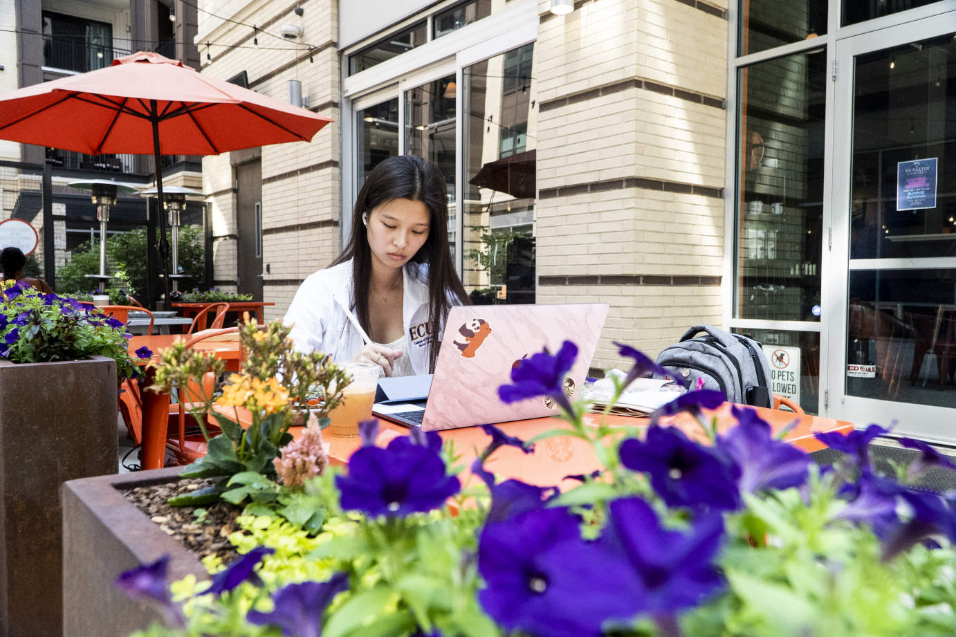 Exterior, a guest sitting in front of a laptop in the patio area