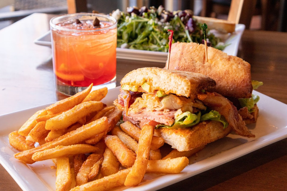 Sandwich served with fries and a class of cocktail