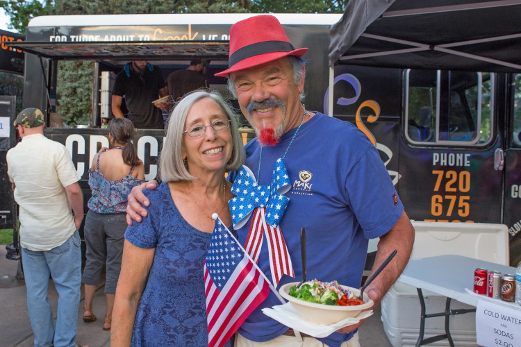 Two people in front of the food truck, hugging and smiling