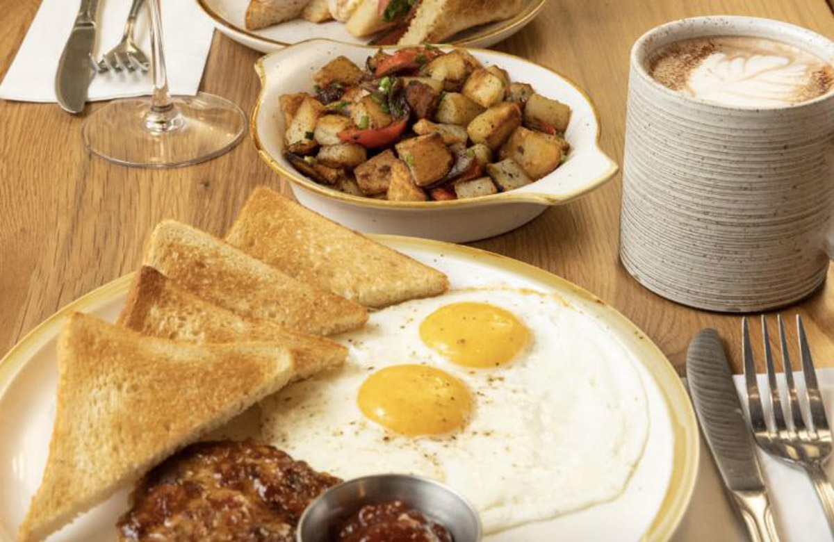 A plate with eggs, toast and coffee on a wooden table