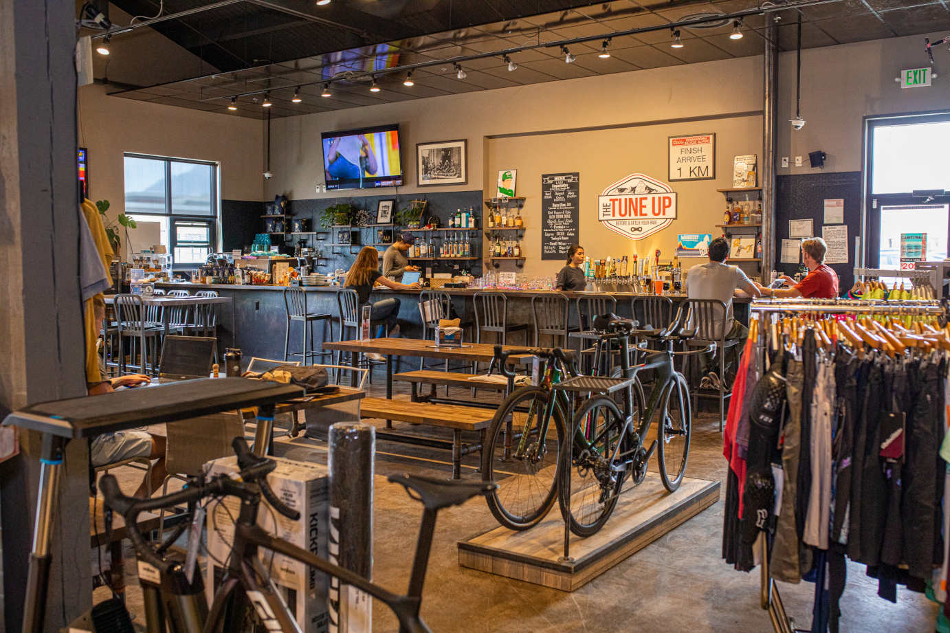 Interior, bike shop adjacent to the seating area, seated guests and staff at the bar