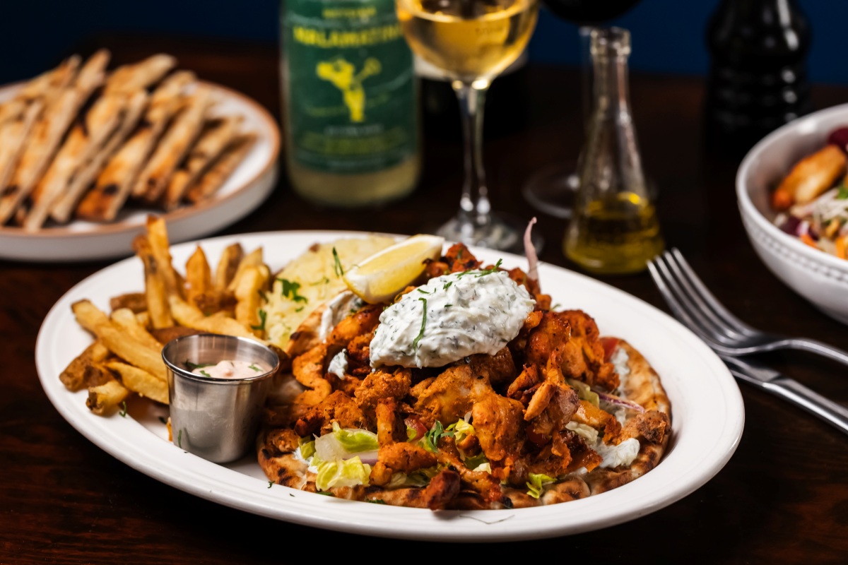 Crispy chicken gyro on pita with fries, tzatziki, and lemon