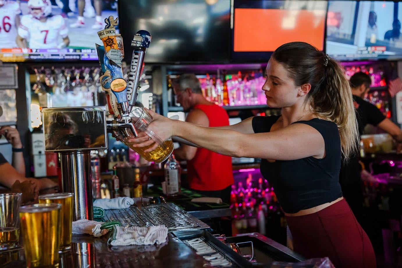 Girl pouring beer on the tap
