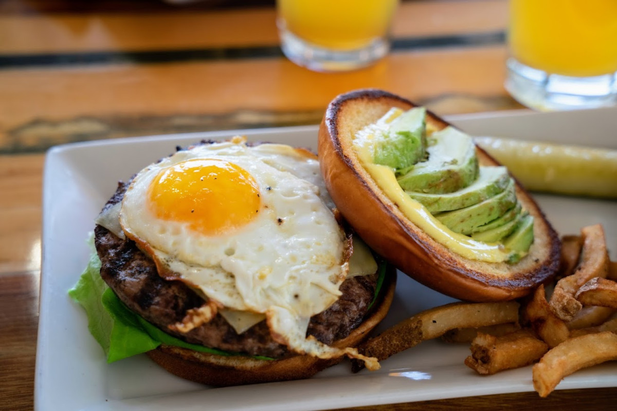 Avocado and egg burger served with fries