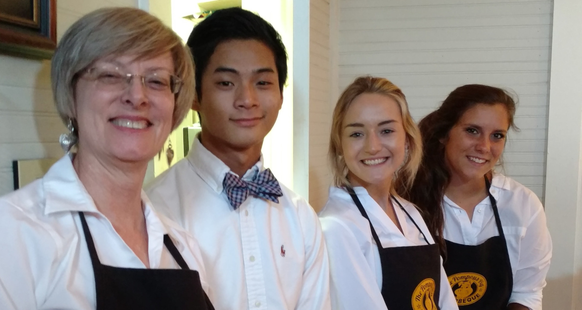 a group of people in aprons standing next to each other.