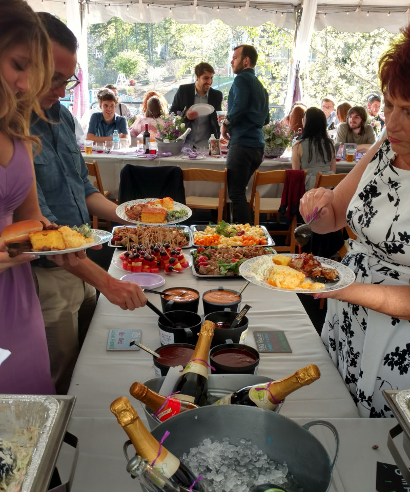 a woman at a buffet wearing a purple dress.