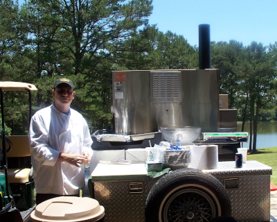 a man standing next to a food cart.