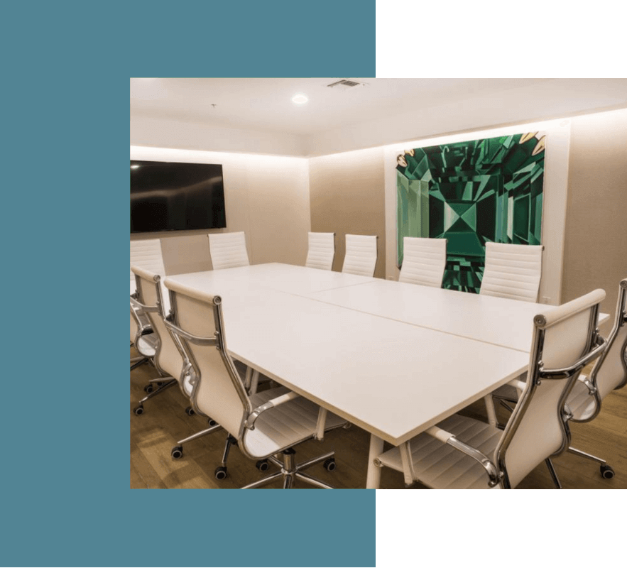 Interior, big white table and chairs with wheels, a TV and artwork on the wall