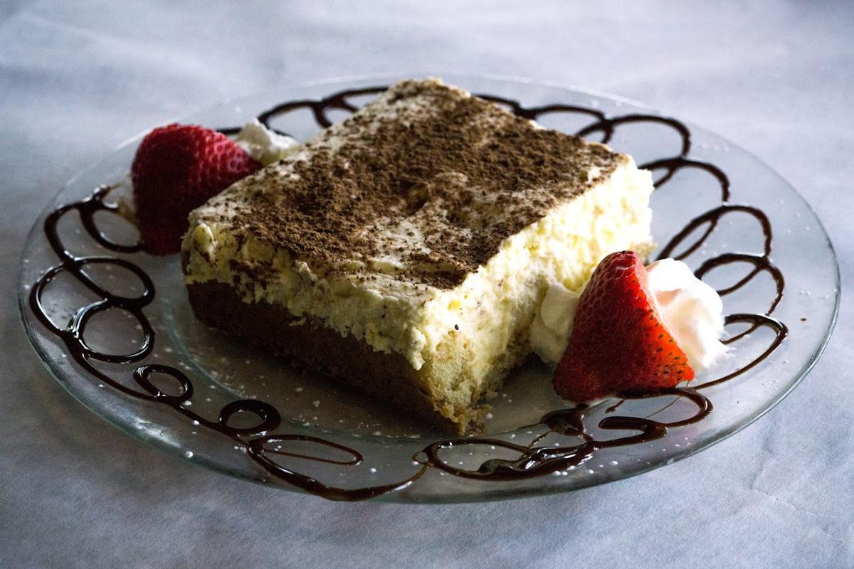 Tiramisu cake, garnished with cream and strawberries
