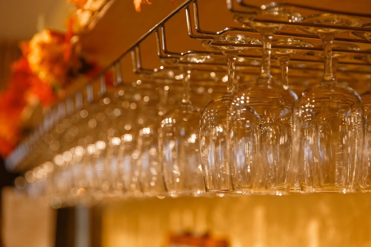 Upturned hanging wine glasses at a bar, close-up
