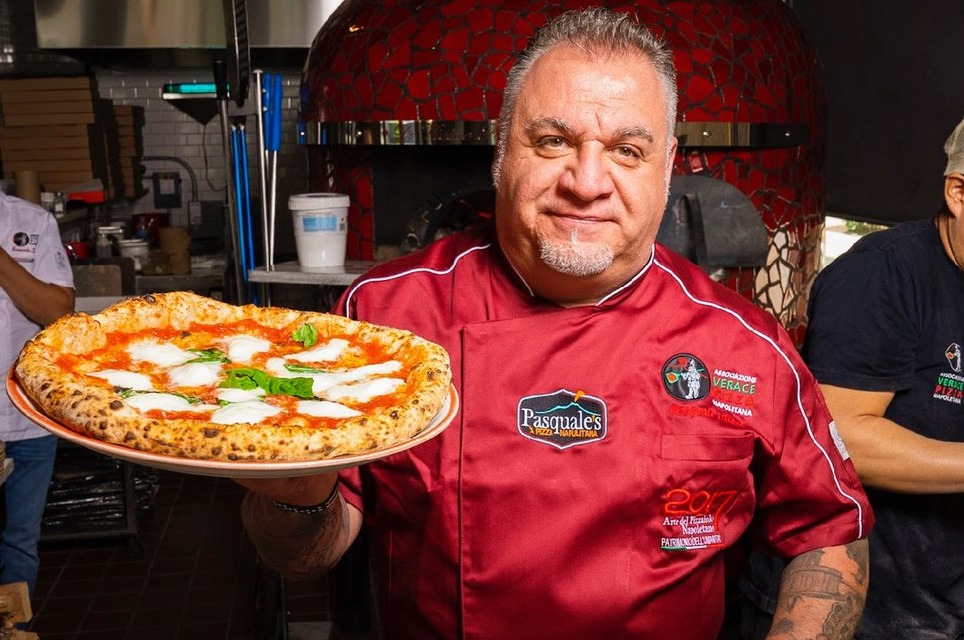 Chef holding a Margherita pizza