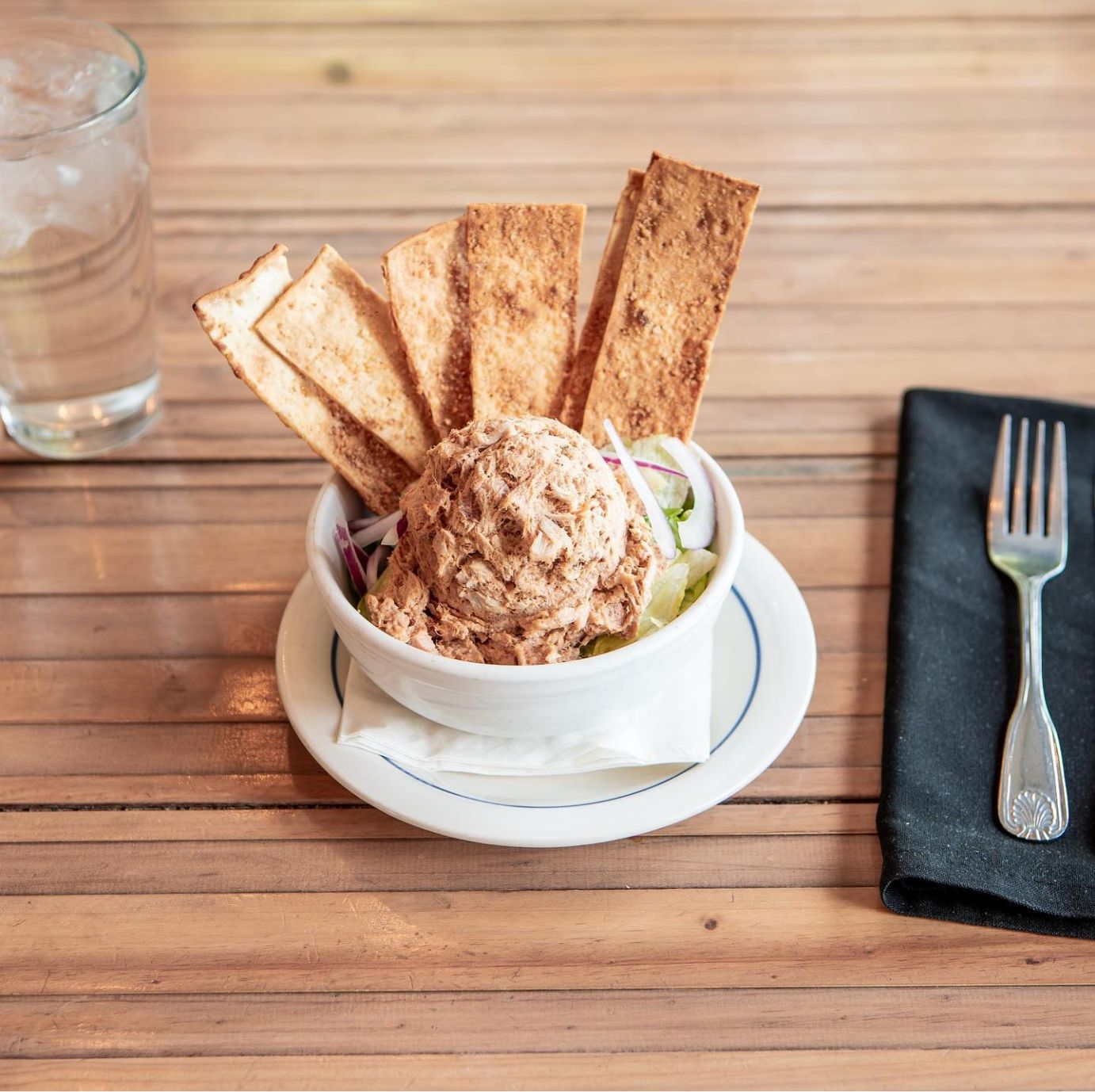 Tuna spread, served in a pot with red onion and flatbread crackers