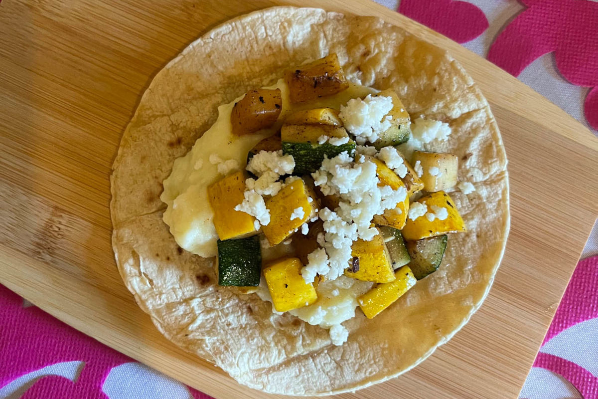Tortilla topped with grilled veggies and white cheese