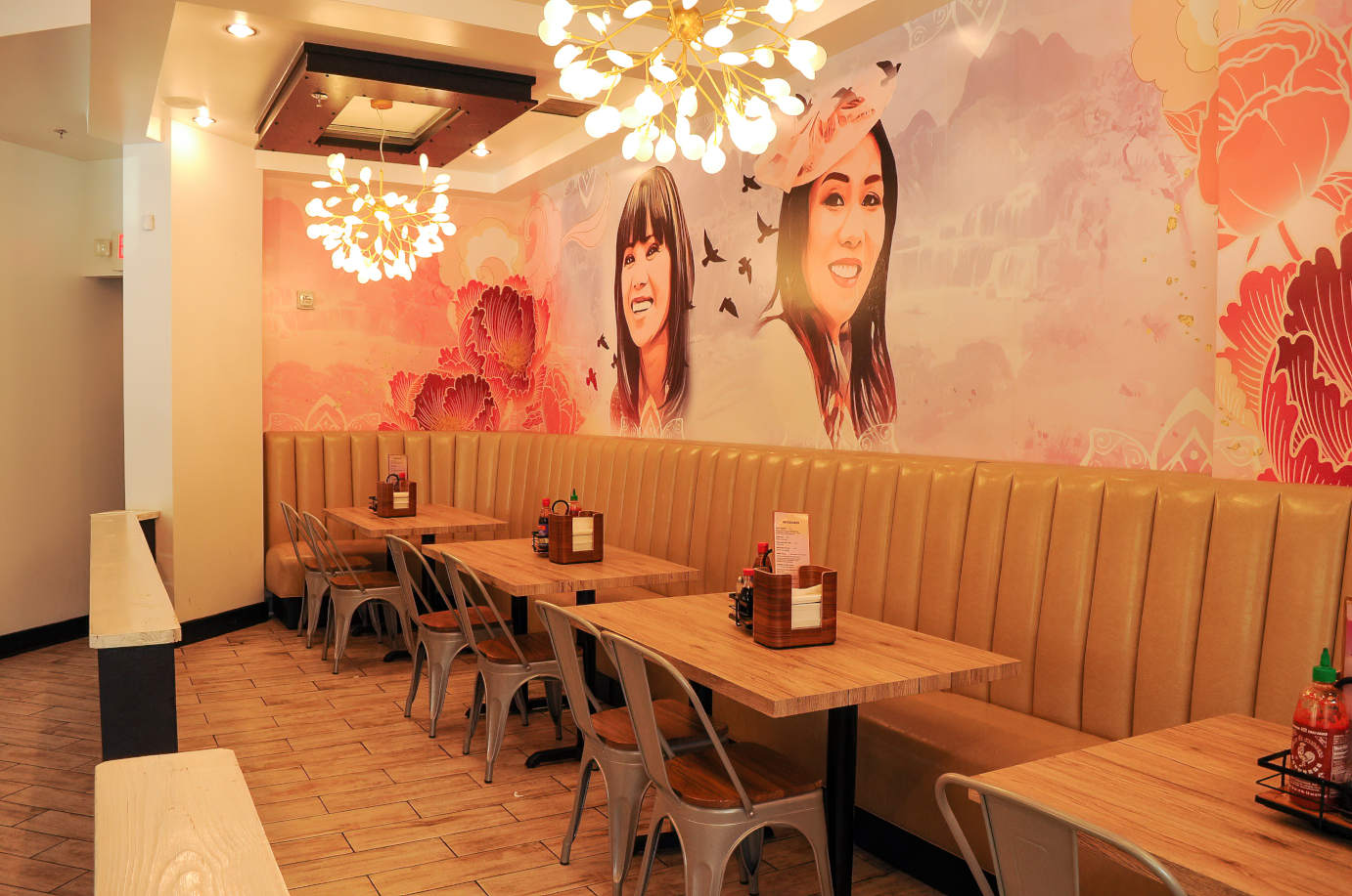 High back banquette seating with tables and chairs by a wall decorated with mural