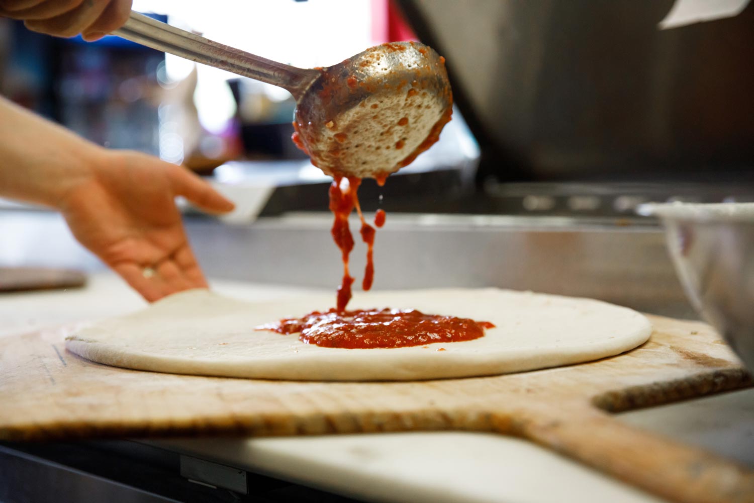 tomato sauce over the pizza dough