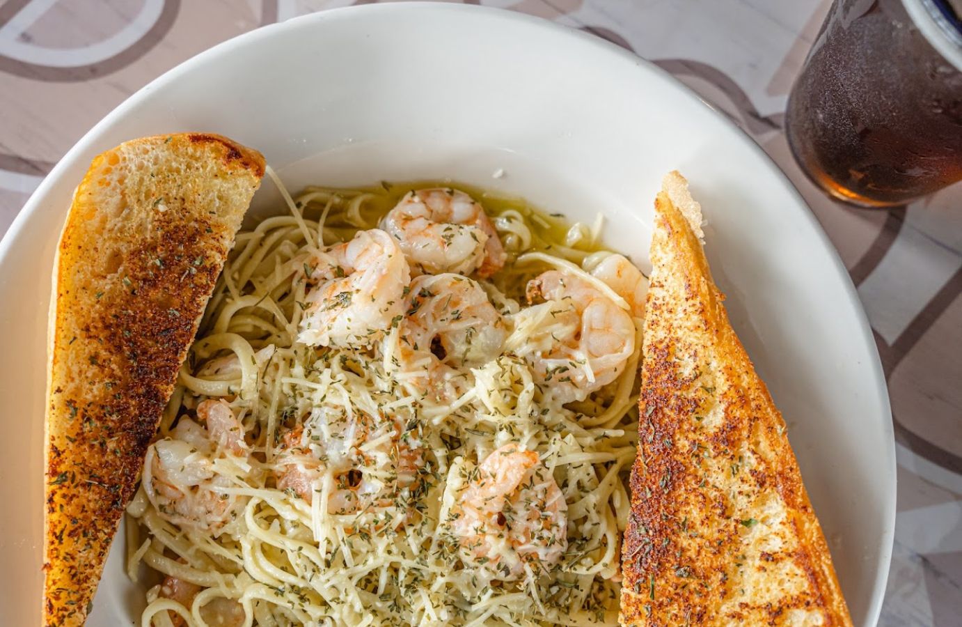 Closeup of a plate with Shrimp Scampi pasta and some toast on the side