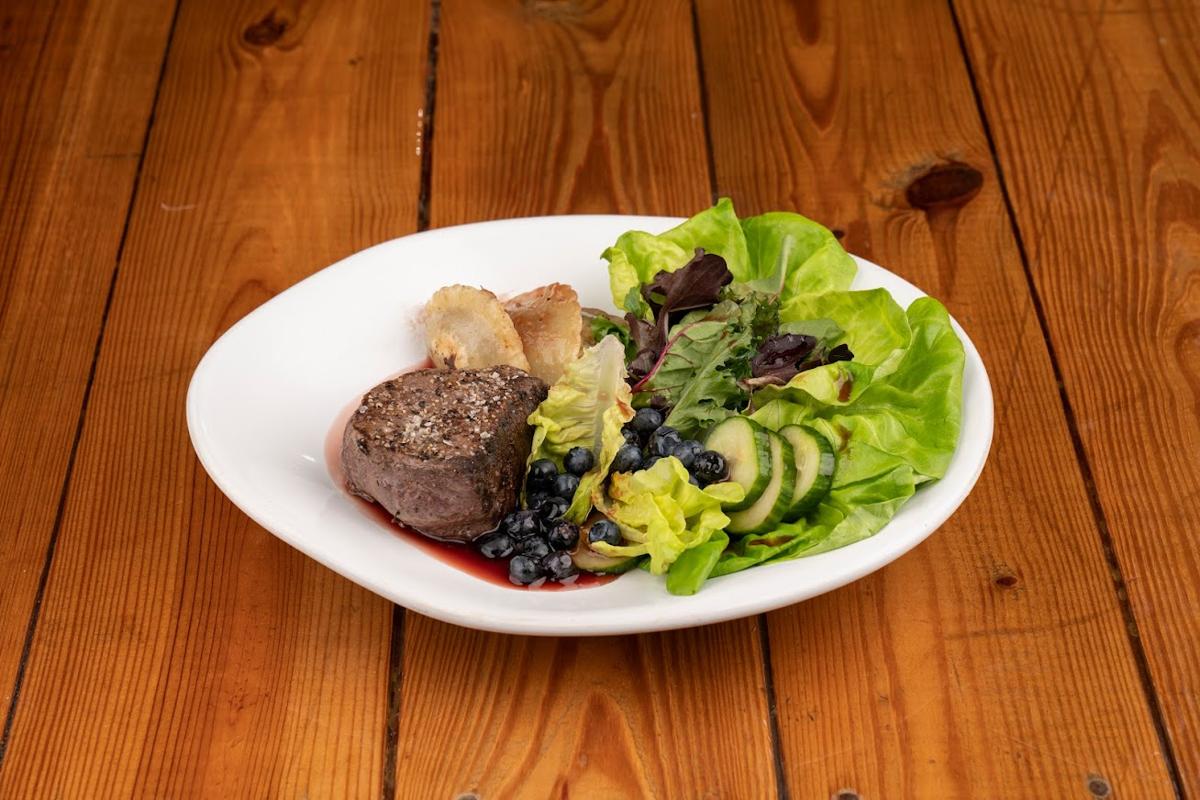 Steak and green salad with blueberries