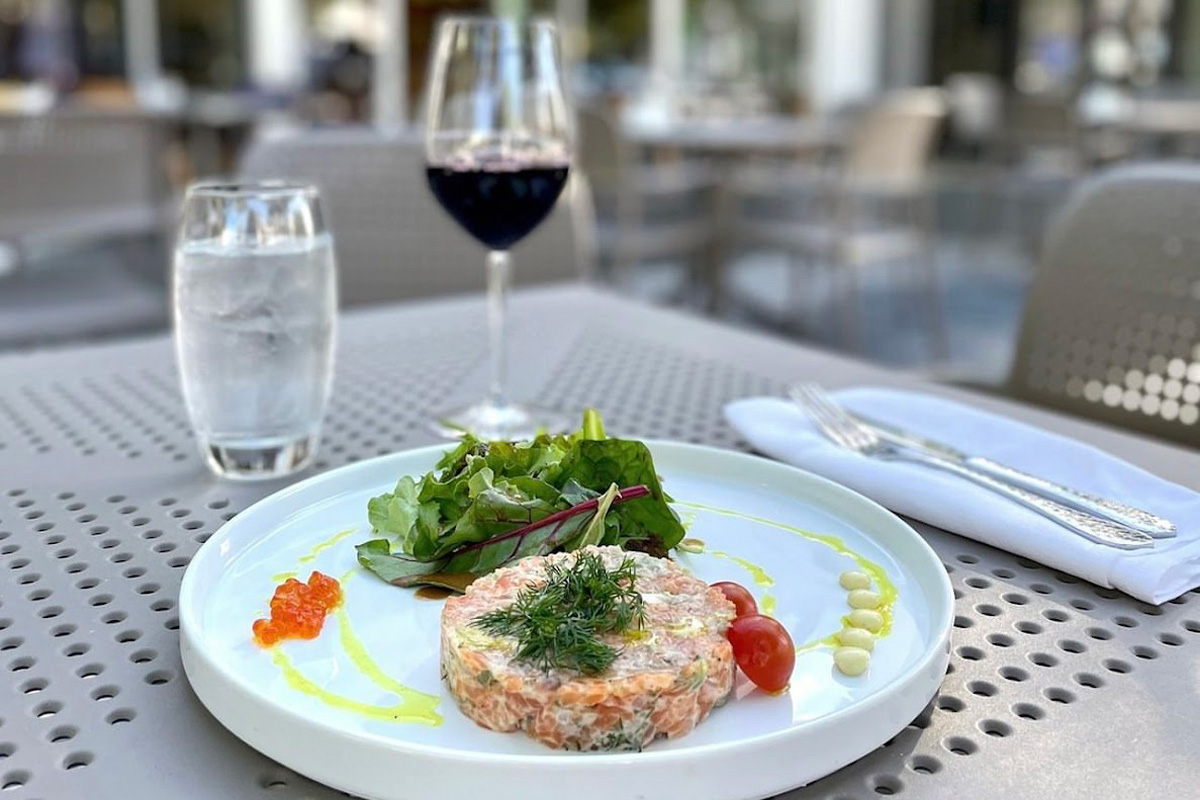 Tartar dish served with red wine in outdoor seating area