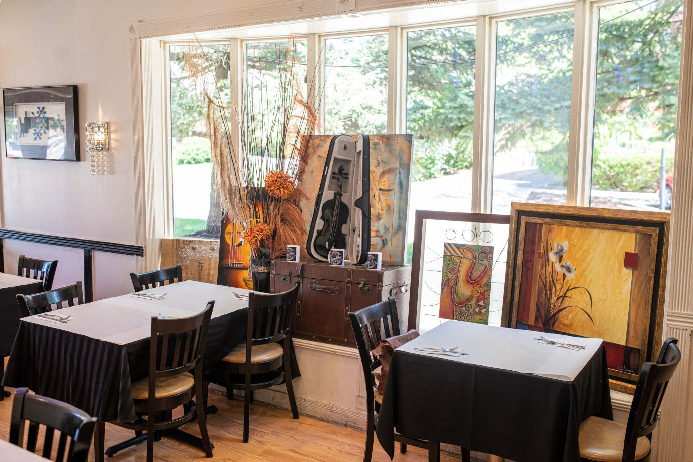 Interior, tables and seats, artworks and decorations leaned against a window